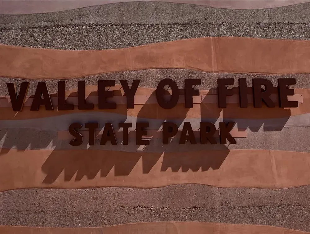 Valley of Fire State Park entrance sign carved into banded sandstone at the park boundary, Nevada
