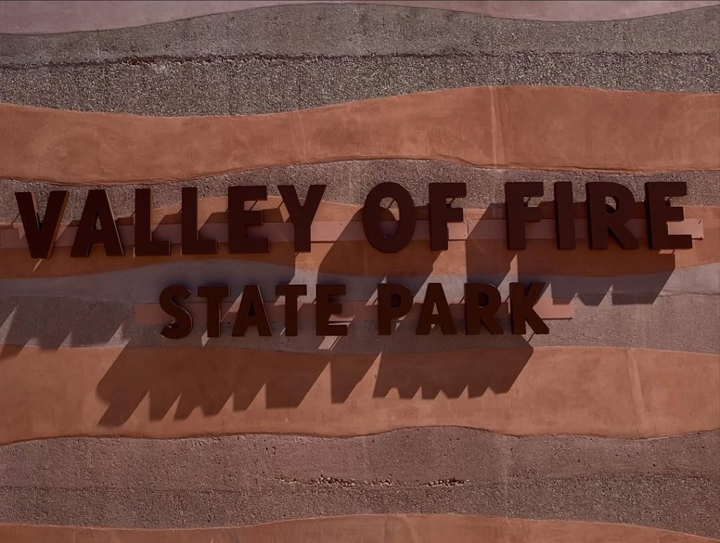 Valley of Fire State Park entrance sign carved into red sandstone rock